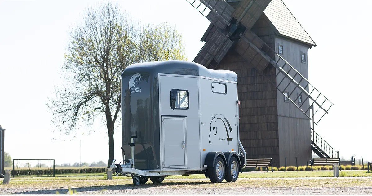 Van Cheval Liberte Touring Jumping coloris Iron Grey, deux places, gare devant un moulin a vent