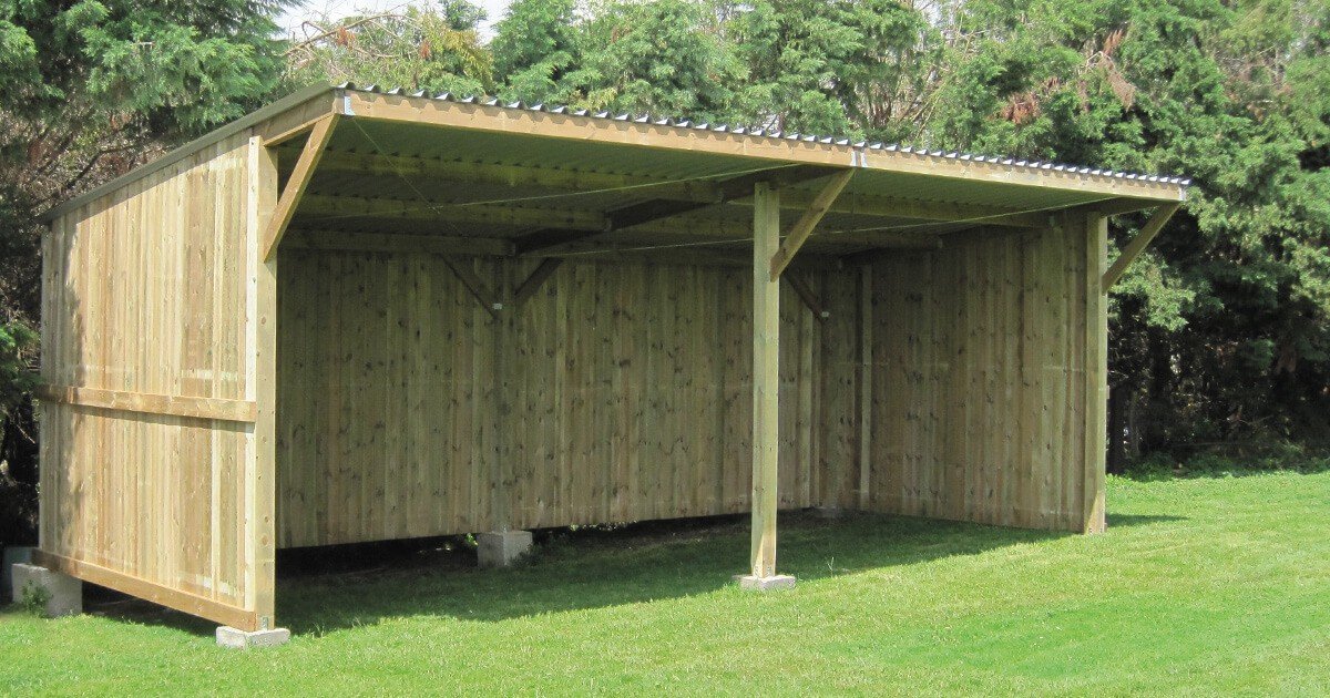 Grand abri de prairie Cheval Liberte en bois traite, facade ouverte, sur herbe