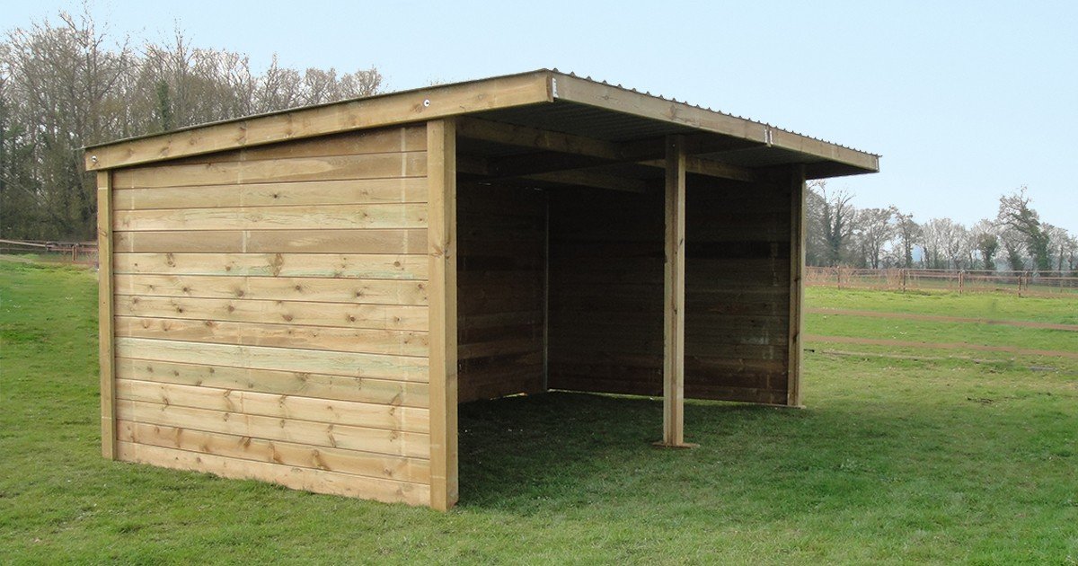 Abri de prairie Cheval Liberte en bois a toit monopente, ouvert sur deux travees, pose dans un pre
