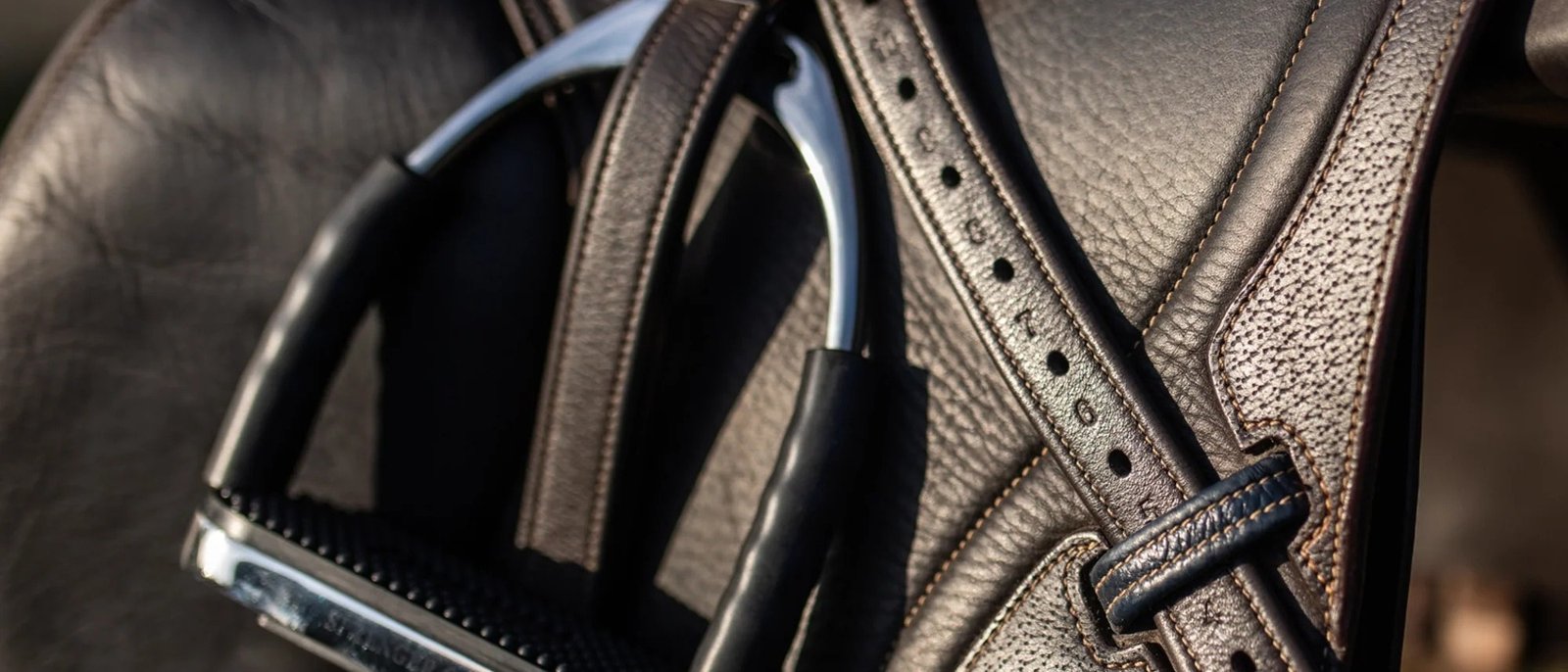 Étrier Sprenger System-4 accroché à une selle en cuir, gros plan