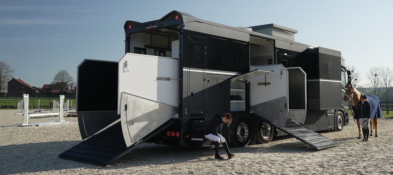 Camion poids lourd Theault gamme Elegance portes et rampes ouvertes sur une carrière, cavalière et cheval