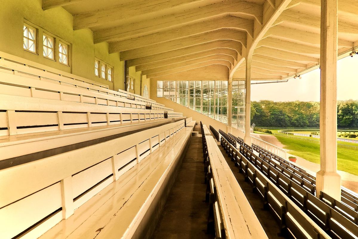 Tribune historique d'un hippodrome français donnant sur la piste, cadre officiel des paris hippiques régulés par l'ANJ
